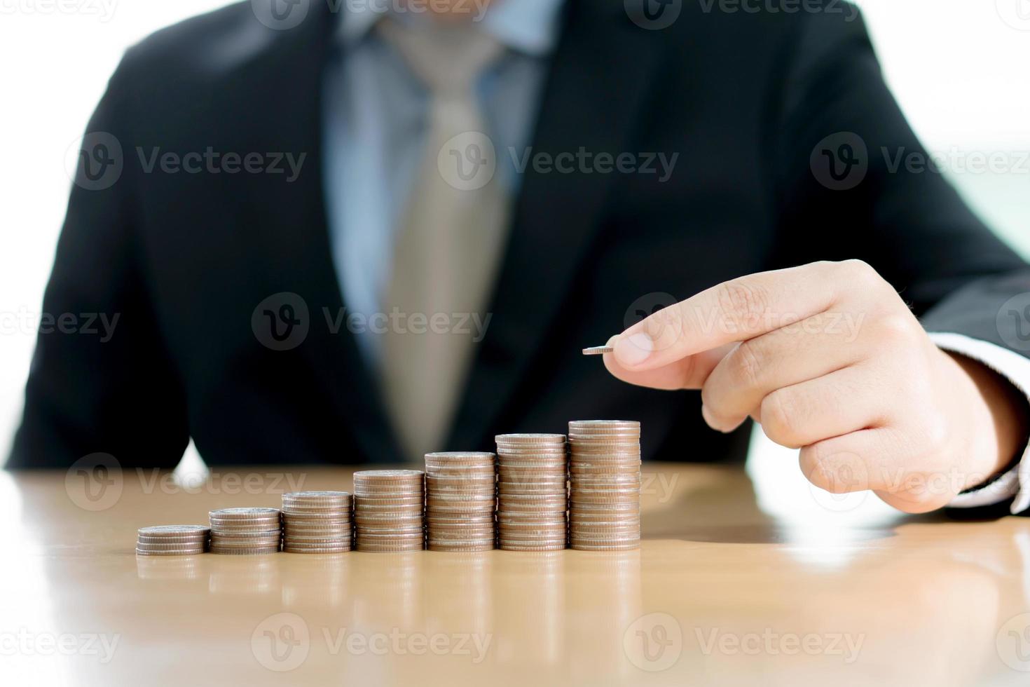 Close-up Of A Businessman Making Stack Of Coins photo