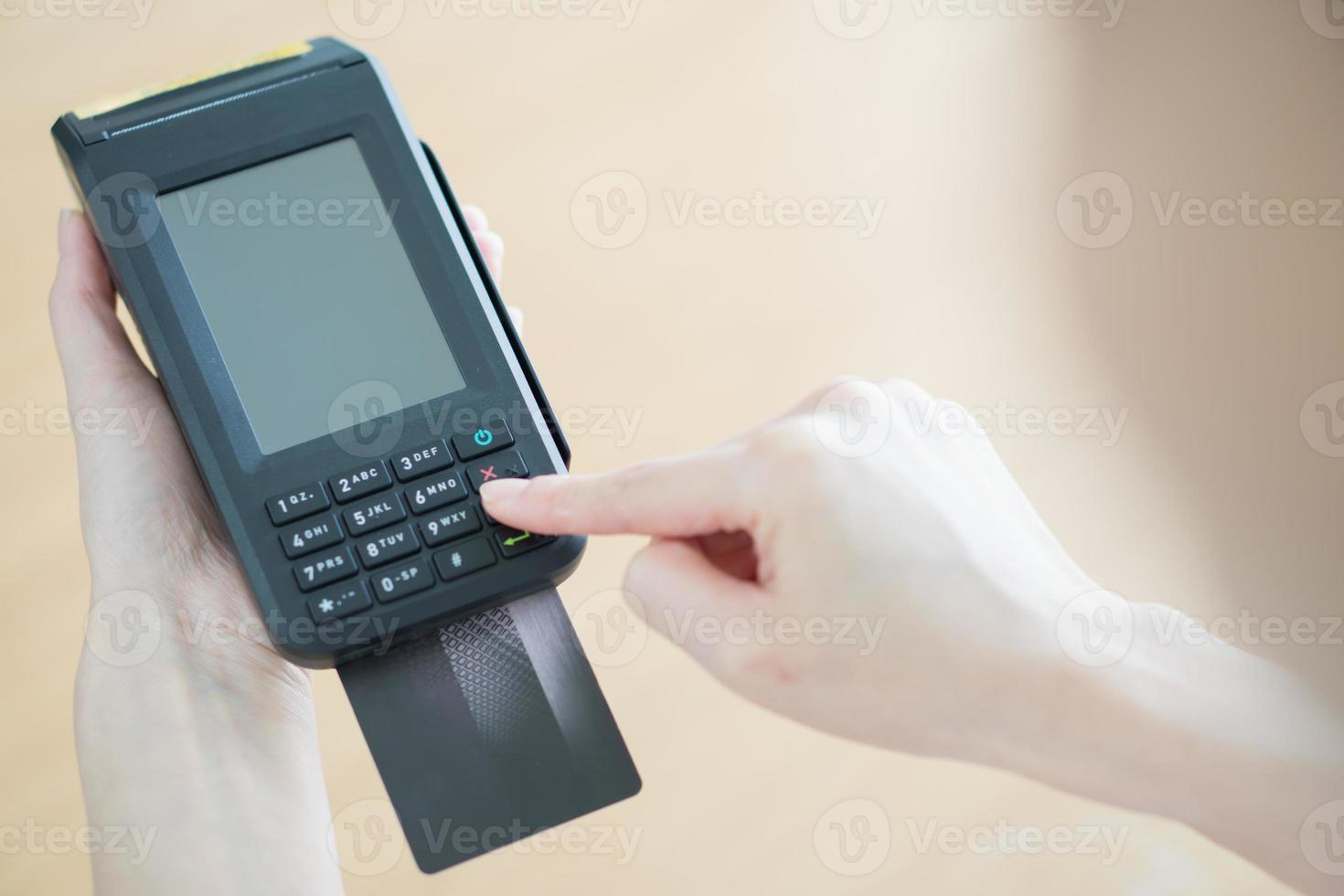 Hand with credit card swipe through terminal photo