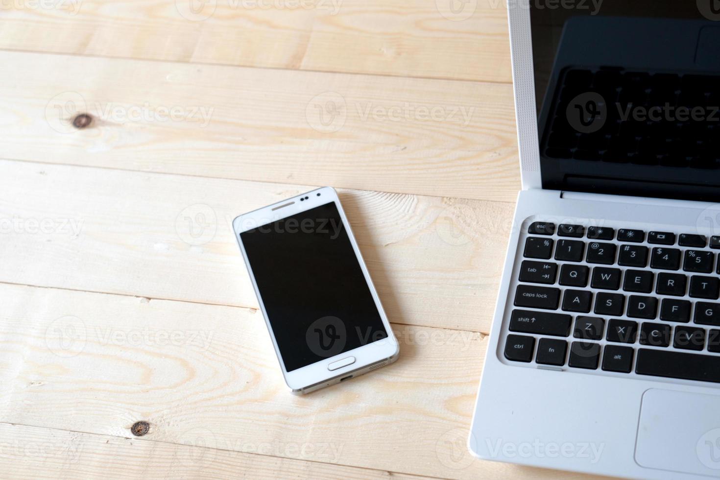 laptop and smart phone on a wooden table. photo