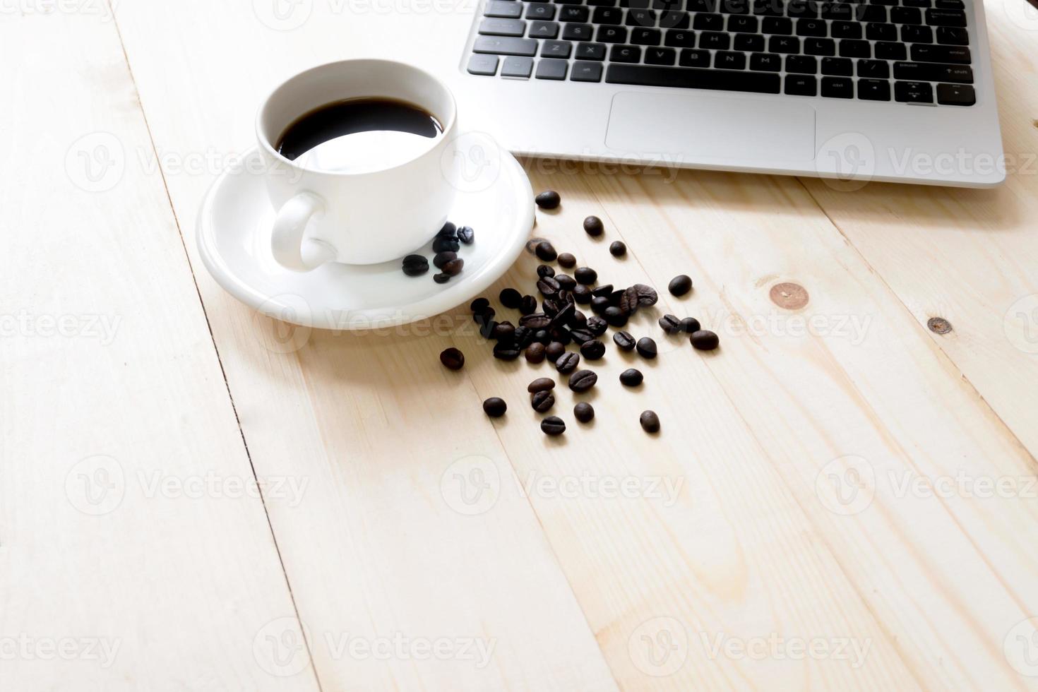 laptop, cup of fresh coffee and coffee beans photo