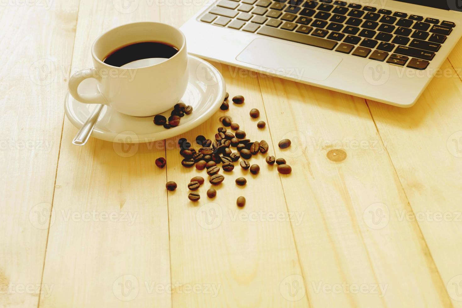 laptop, cup of fresh coffee and coffee beans photo