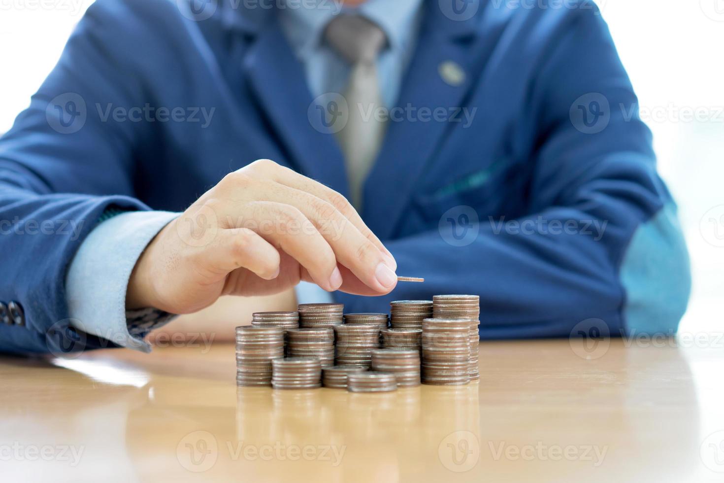 Close-up Of A Businessman Making Stack Of Coins photo