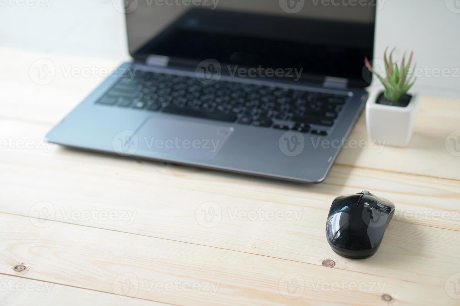 Laptop and mouse on table photo
