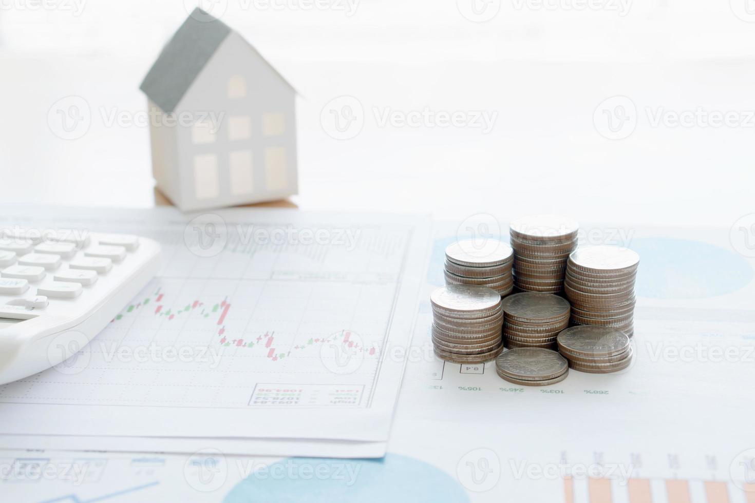 With House Model And Stack Of Coins On Desk photo