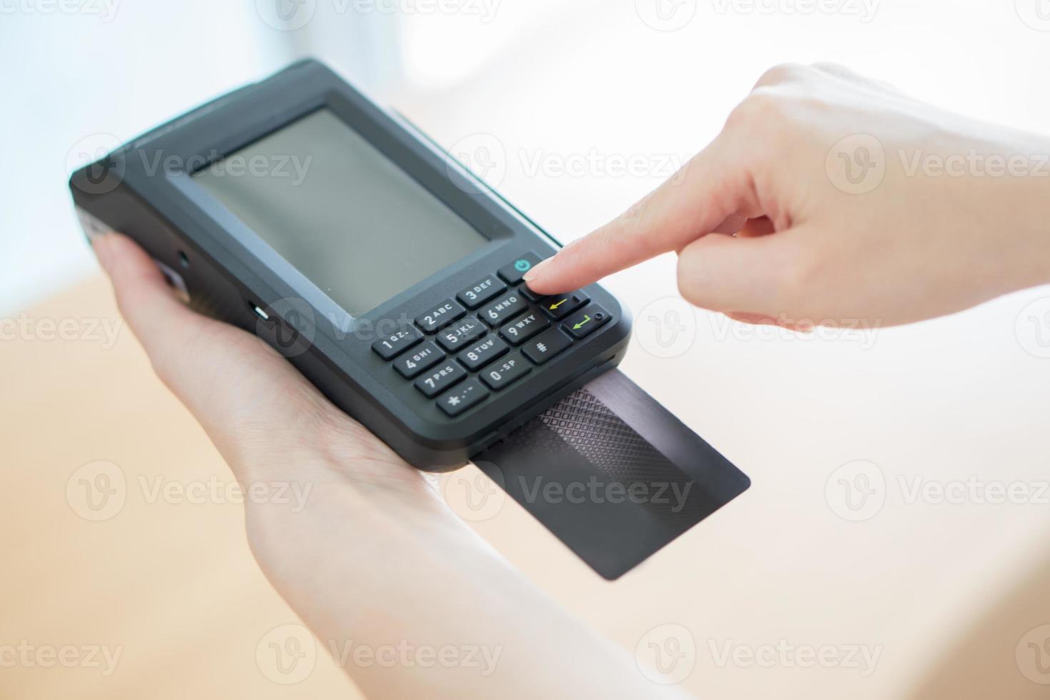 Hand with credit card swipe through terminal photo