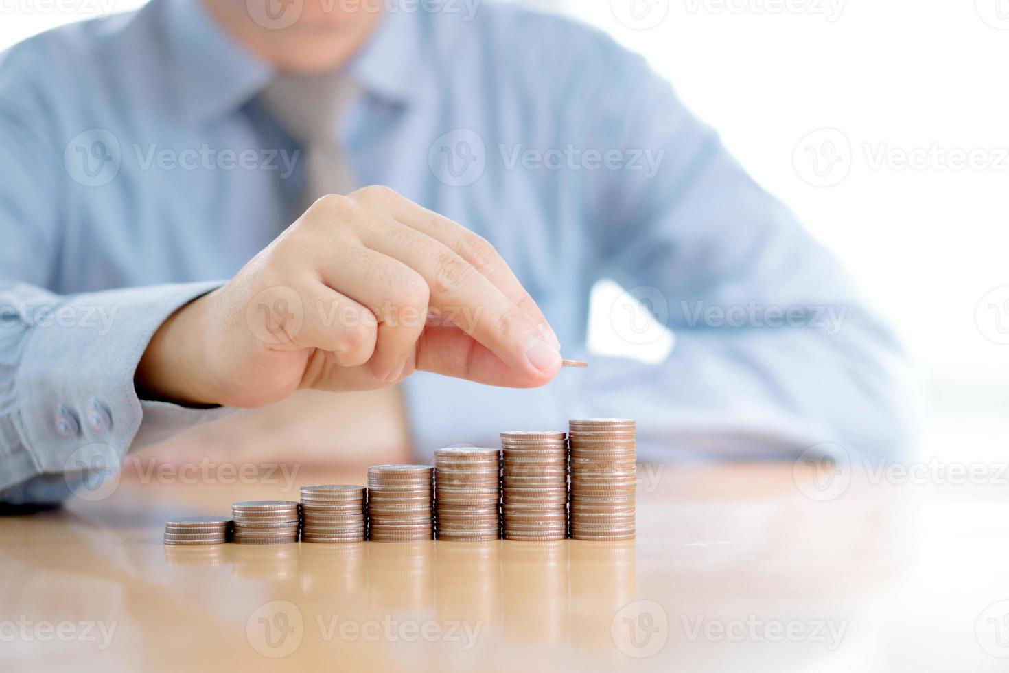 Close-up Of A Businessman Making Stack Of Coins photo