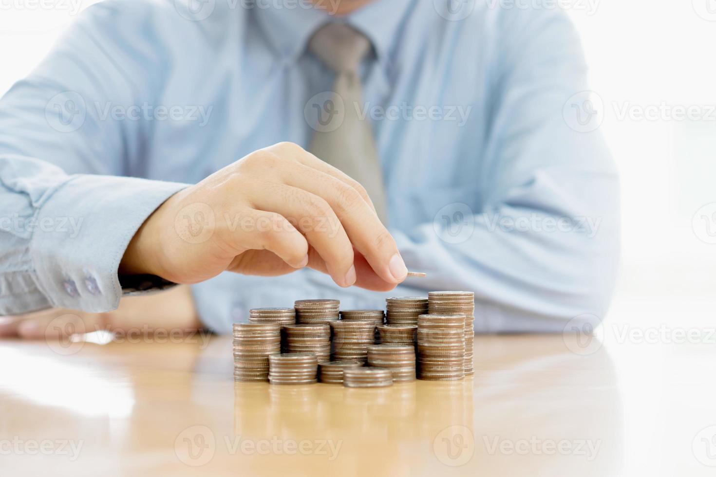 Close-up Of A Businessman Making Stack Of Coins photo