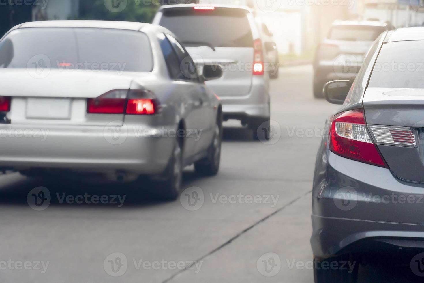 Rush hour cars in the city streets but the traffic flows smoothly. Rear side of cars driving on concrete road. photo