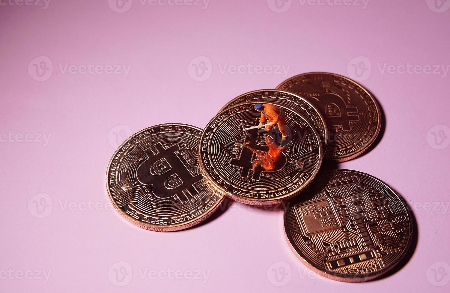 Technician worker figure standing on bitcoin. Bitcoin mining concept. photo