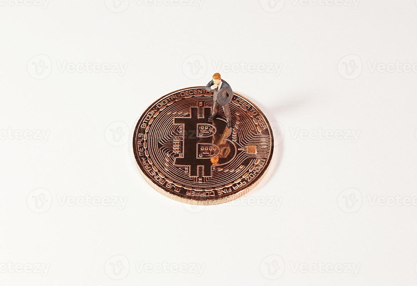 Business man figure standing on bitcoin. Bitcoin mining concept. photo