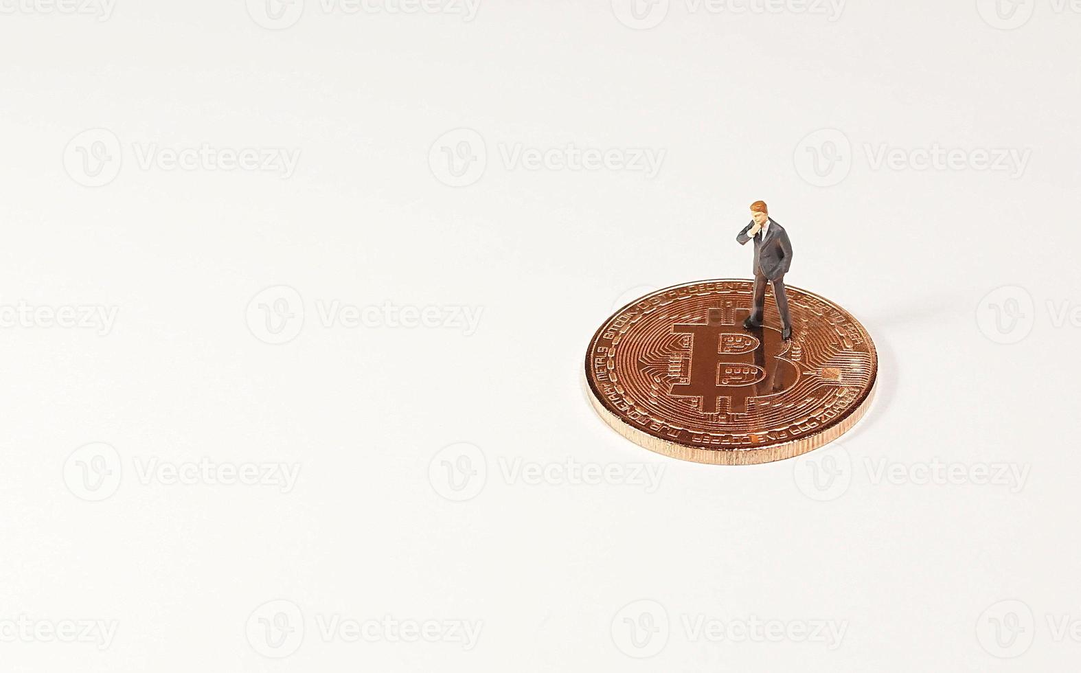 Business man figure standing on bitcoin. Bitcoin mining concept. photo