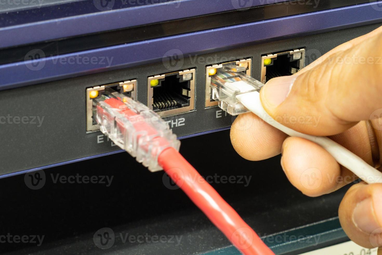 Hand of a man holding The network cables to connect the port of a switch to connect internet network, concept Communication technology photo