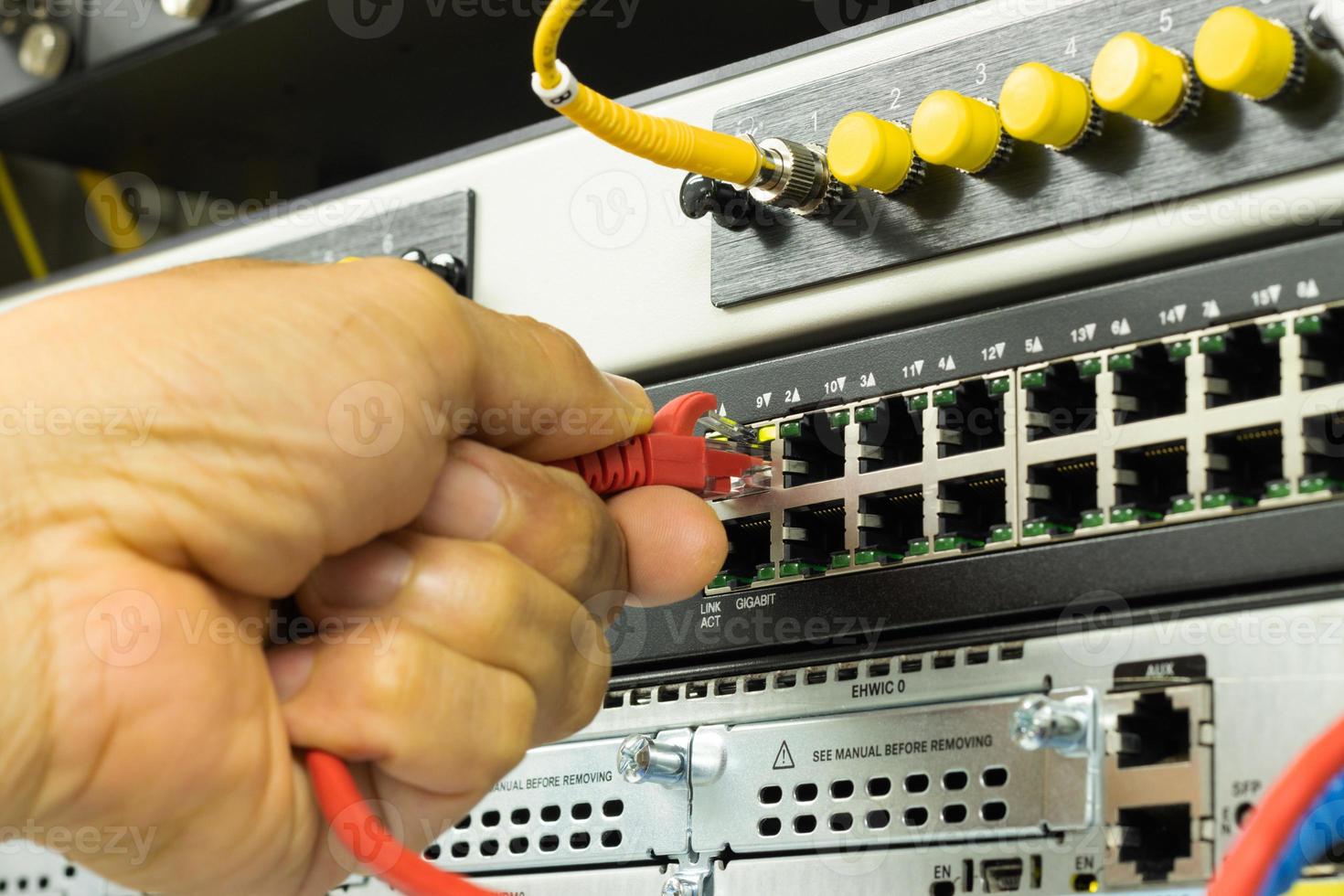 Hand of a man holding The network cables to connect the port of a switch to connect internet network, concept Communication technology photo