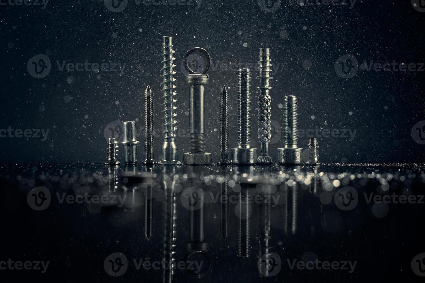 Abstract panorama of city with reflection, made by metal bolt and nut chrome. Black background with bokeh. photo