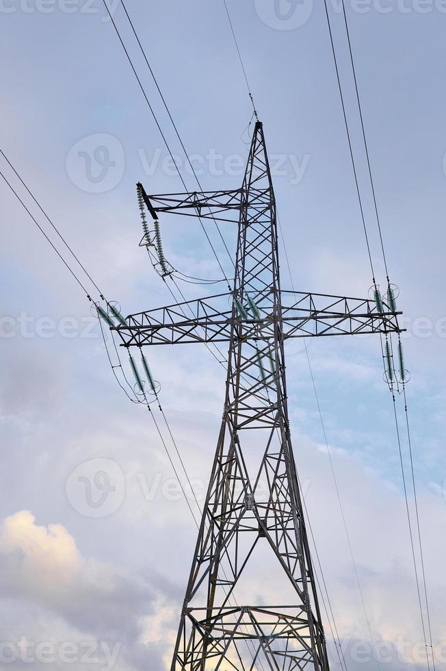 High voltage power lines with electricity pylons against the blue sky. photo