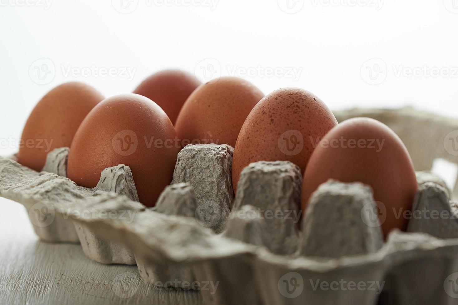Eggs in a protective container on white background. Foreground and background in blur. photo