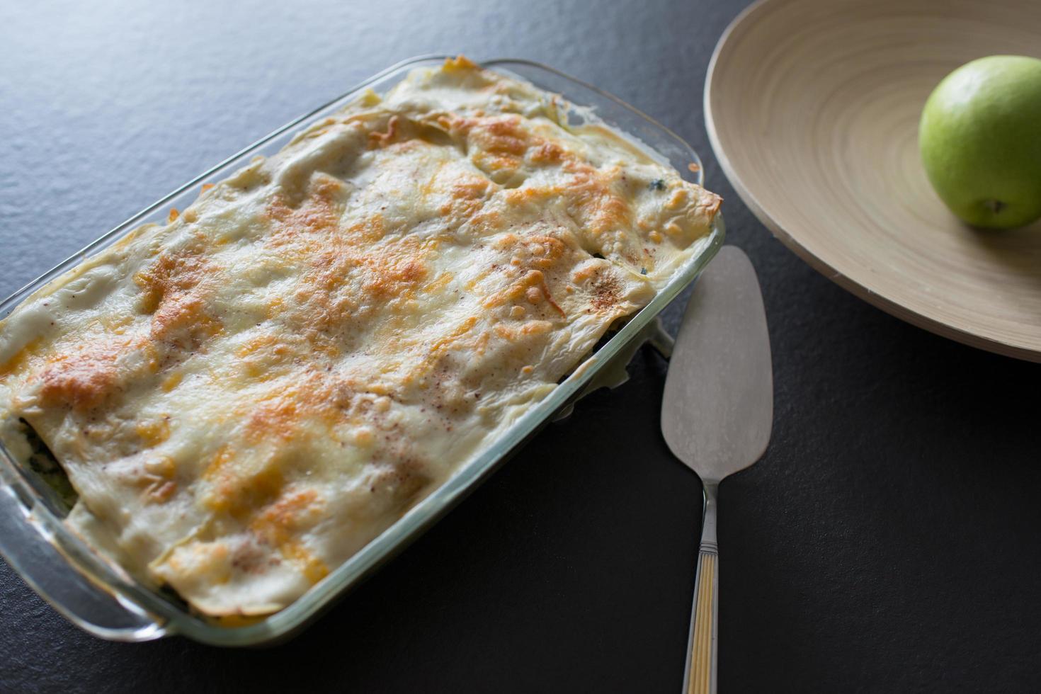 Flat lay of homemade lasagna on a black kitchen counter. photo