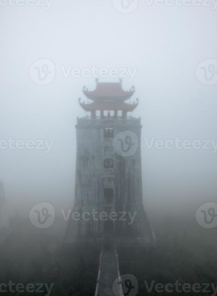 Temple tower on peak mountain in misty photo