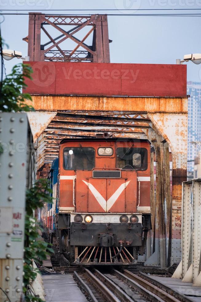 Train running on ancient railway on Long Bien bridge in Hanoi photo