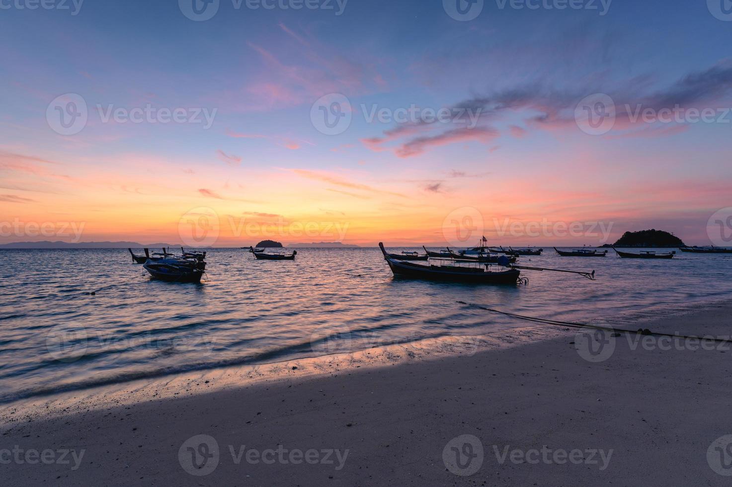 hermoso mar tropical con bote de madera en la mañana del amanecer foto