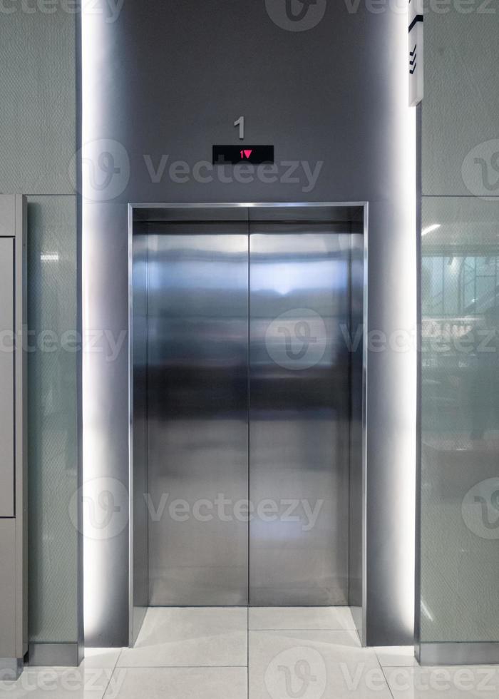 Closed elevator doors glossy illuminated in hotel photo