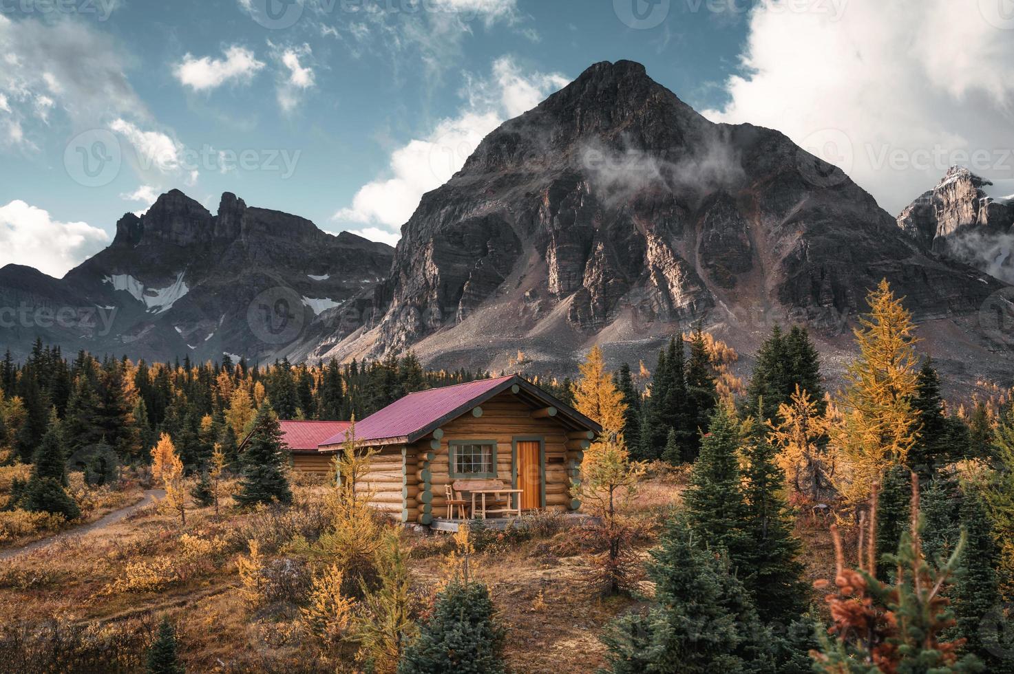 Wooden huts with rocky mountains in autumn forest at Assiniboine provincial park photo
