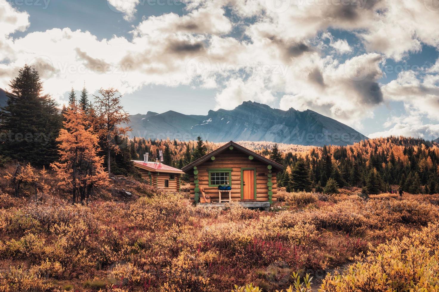 Wooden huts with rocky mountains in autumn forest at Assiniboine provincial park photo