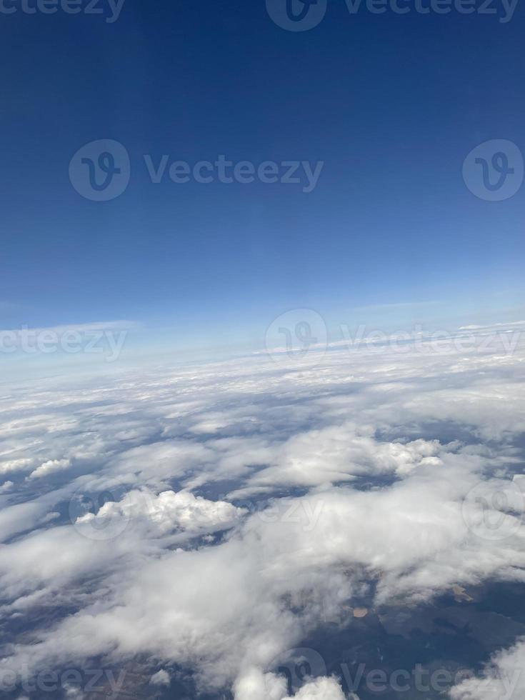 View of the clouds from the plane. White clouds against the blue sky close-up. Beautiful aerial view of the clouds photo