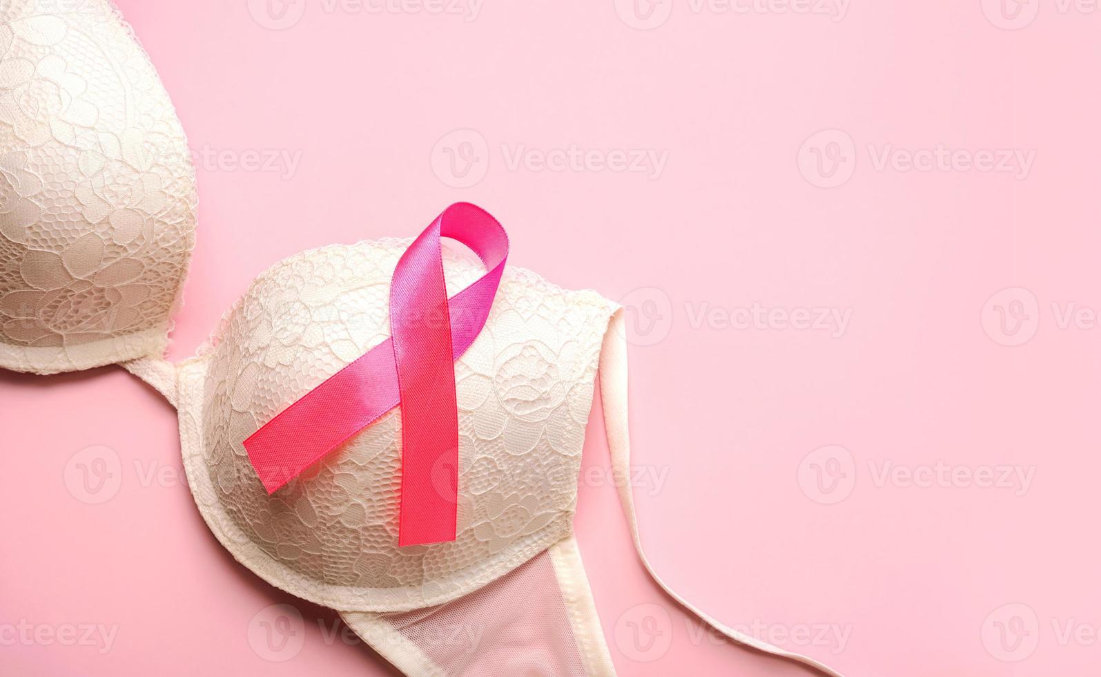 concepto de cáncer de mama. sostén de mujer y cinta rosa símbolo de concienciación sobre el cáncer de mama con espacio para texto foto