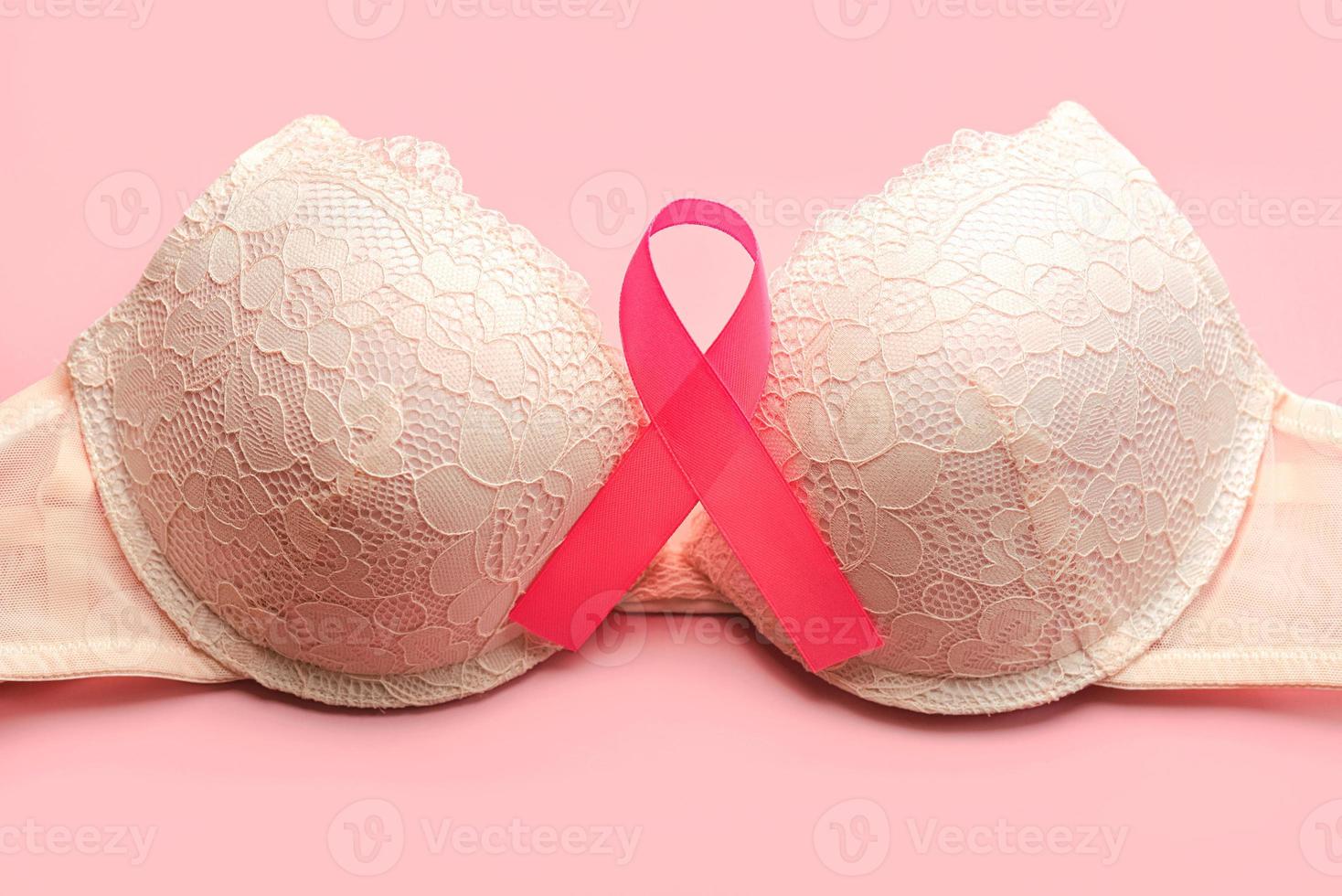 concepto de cáncer de mama. vista superior del sostén de la mujer y el símbolo de la cinta rosa conciencia del cáncer de mama foto