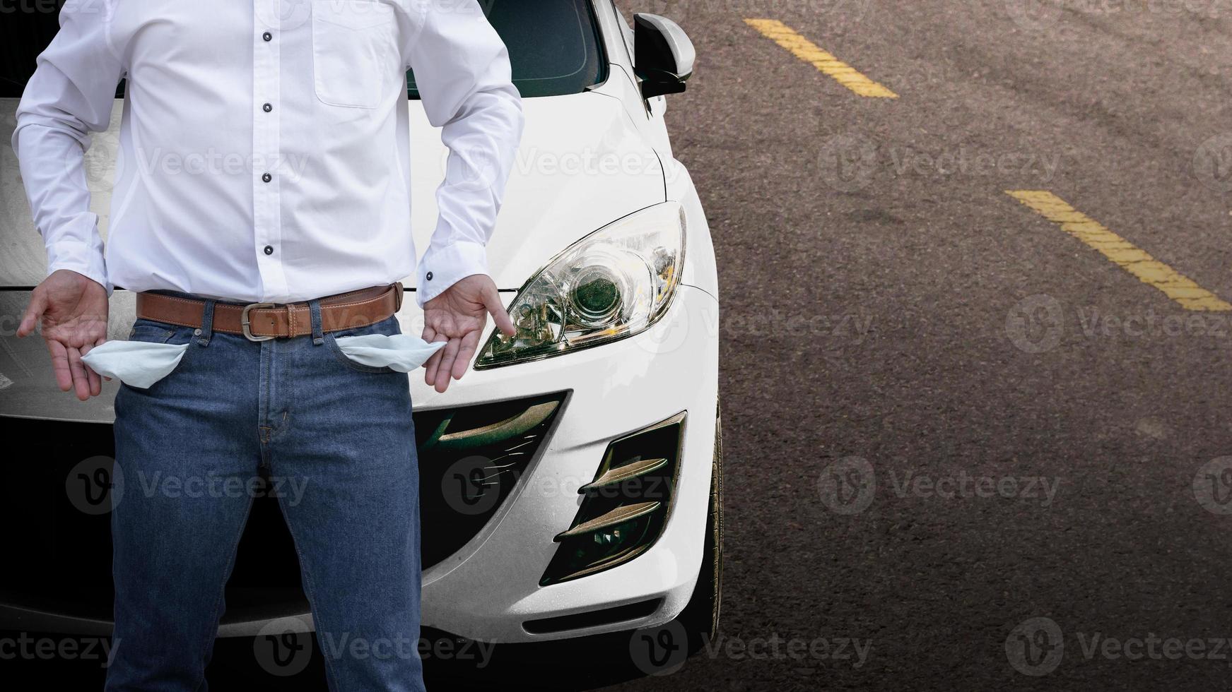 Man showing his empty pockets with white car background. photo