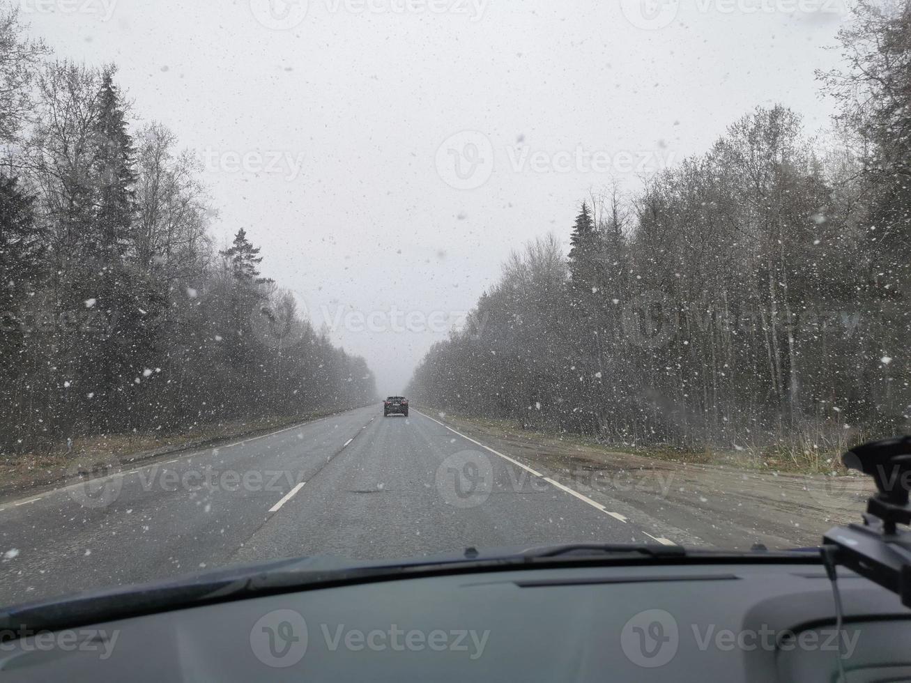 snow falls on the road to meet the cars photo
