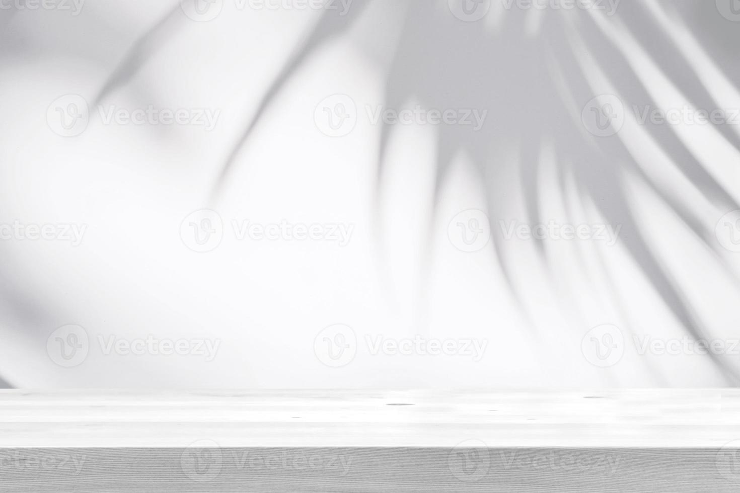Empty wooden table with shadow of tropical leaves on background with copy space photo