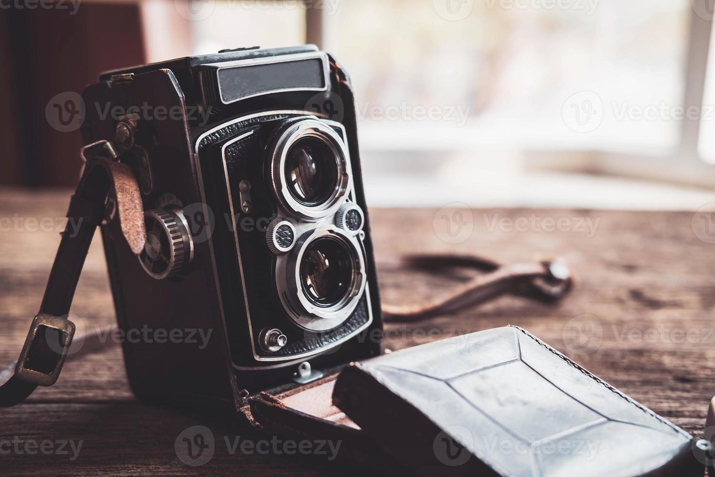 Old retro camera on old wooden background photo