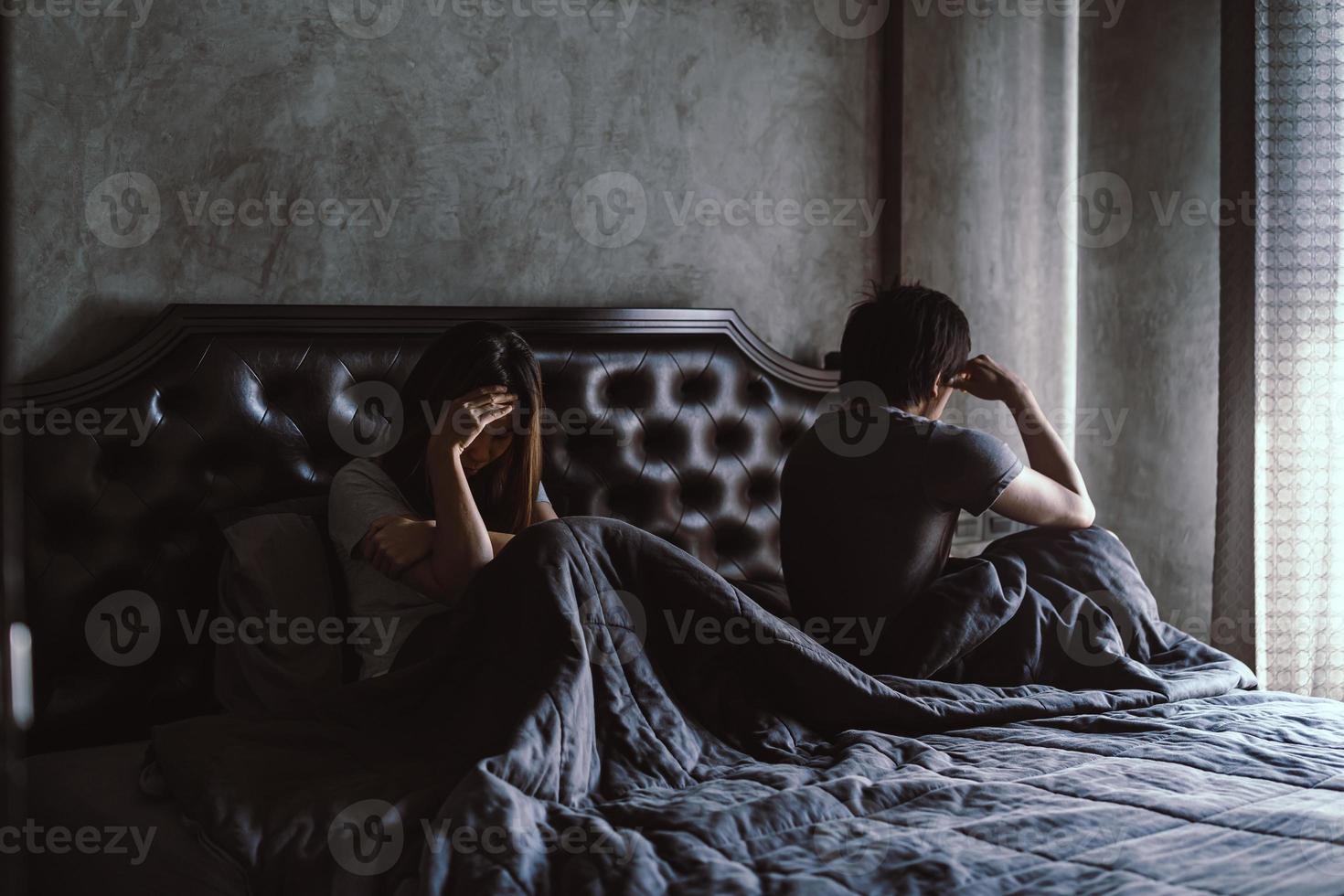 Depressed couple having problem sitting head in hands in the derk bedroom at home photo