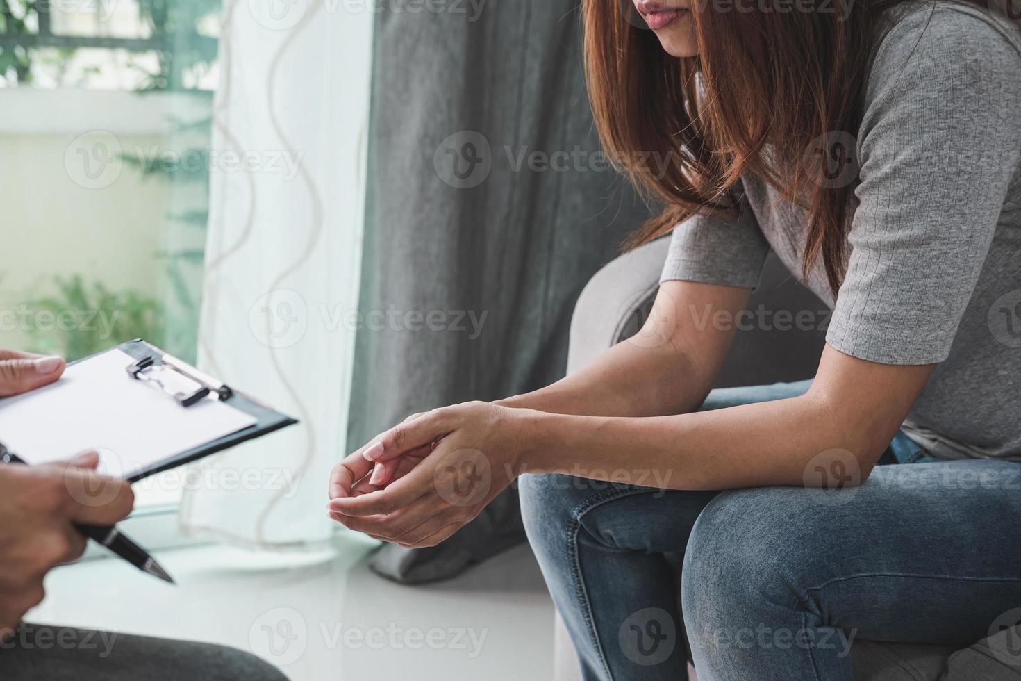 Professional psychologist doctor holding clipboard and filling medical patient information consulting his depressed patient photo