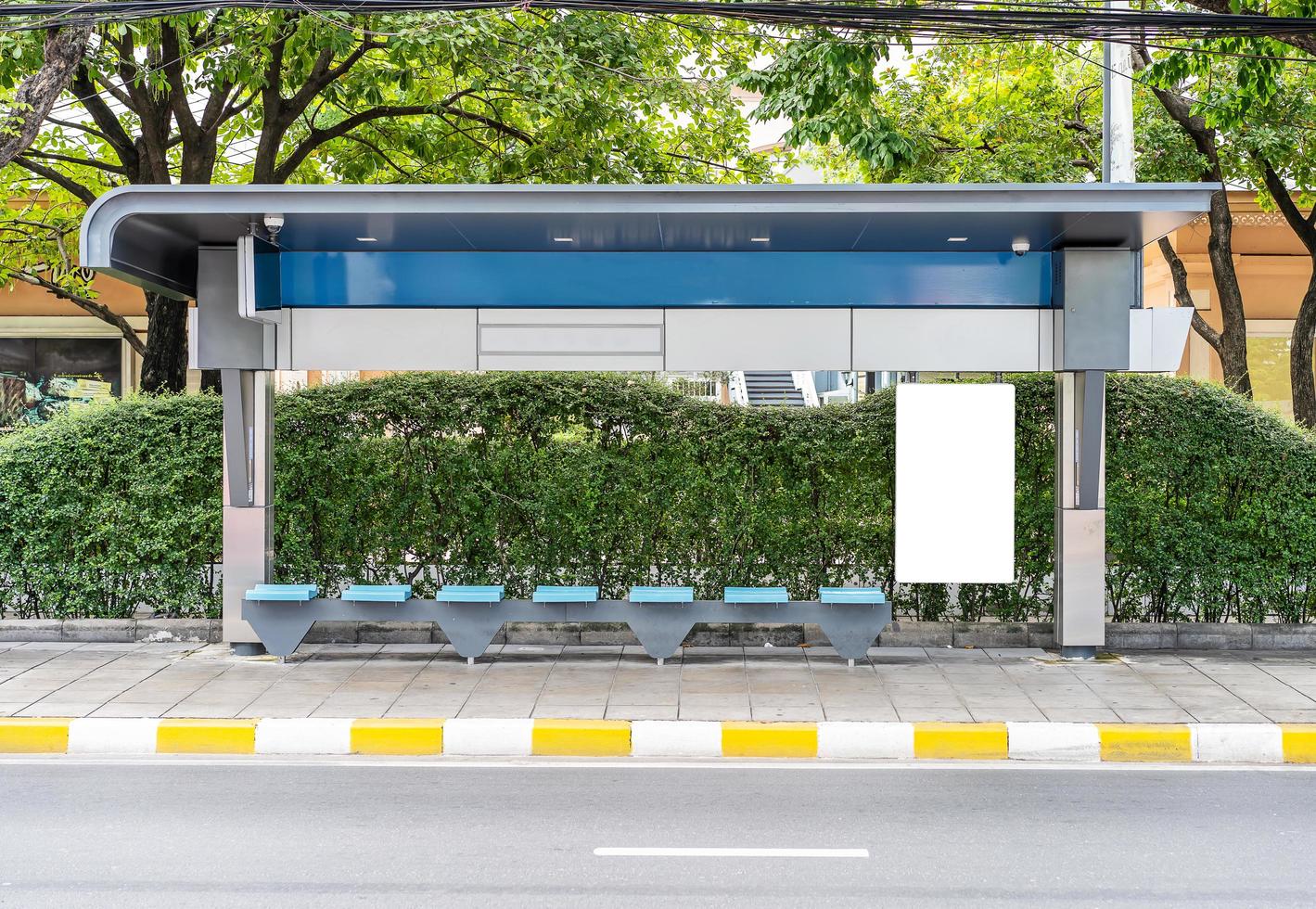 diseñe una maqueta blanca en blanco para su anuncio o gráfico de la cartelera vertical de la parada de autobús en una calle vacía foto