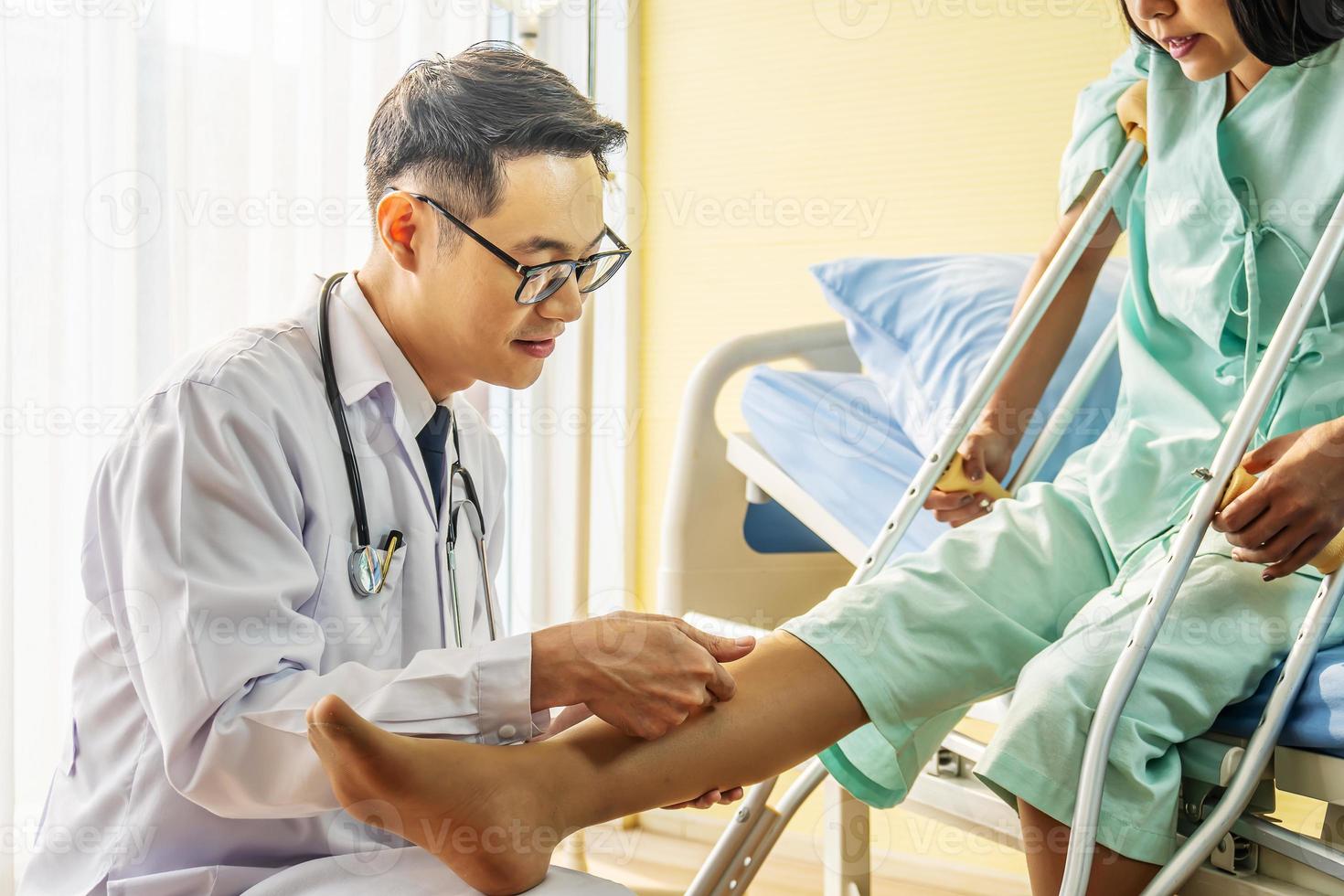 Close-up of Doctor examining female patient with injured leg or knee in clinic, Sport exercise injuries. photo
