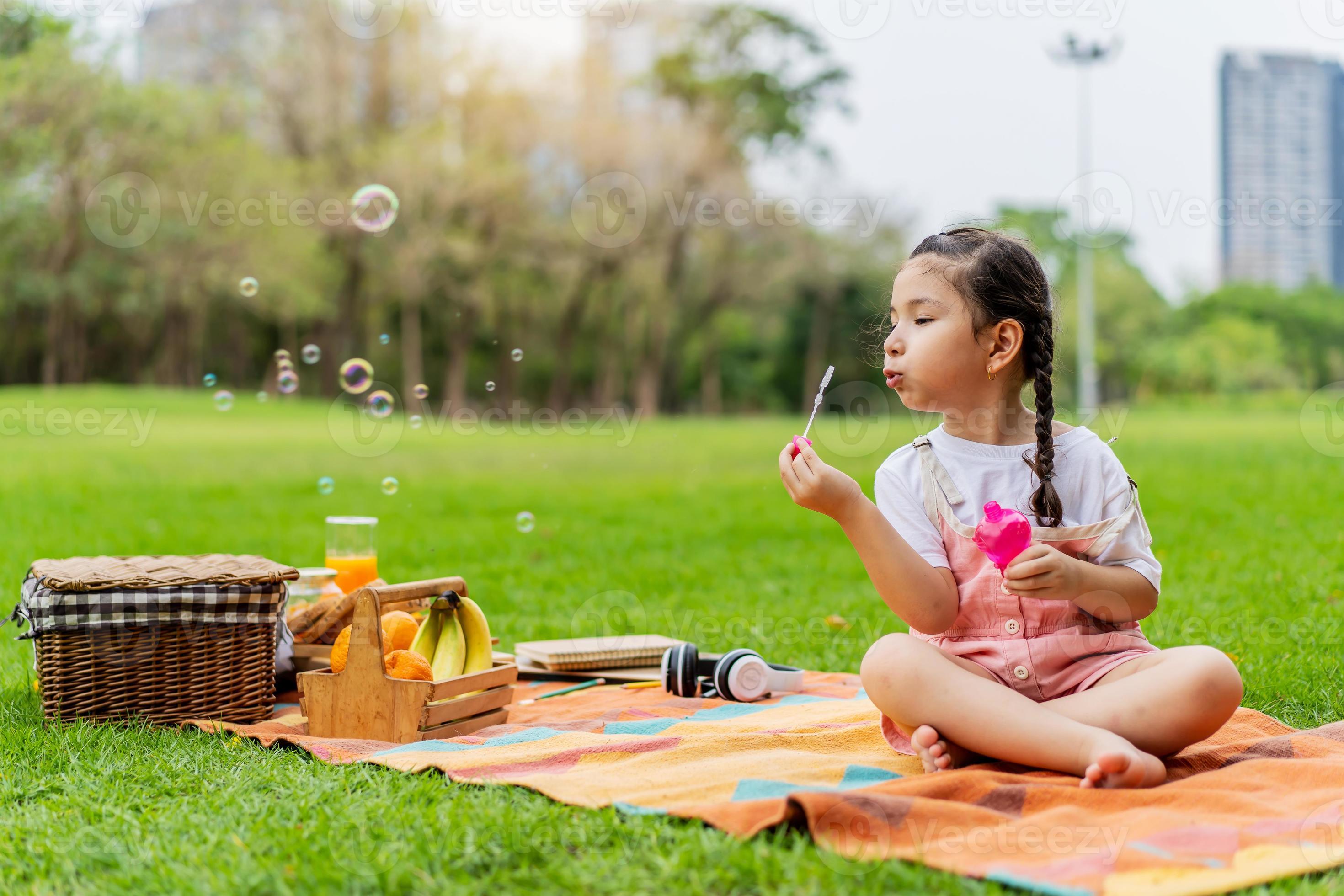 Niños jugando en el parque con pompas de jabón Stock Photo