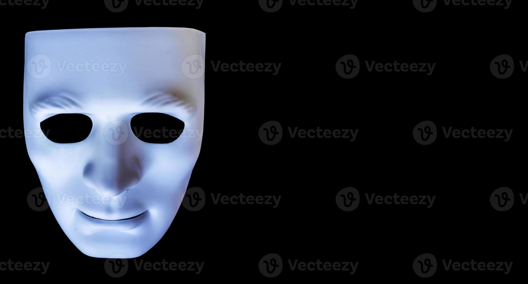 White color plastic face mask isolated on a black background for drama, Halloween style. photo