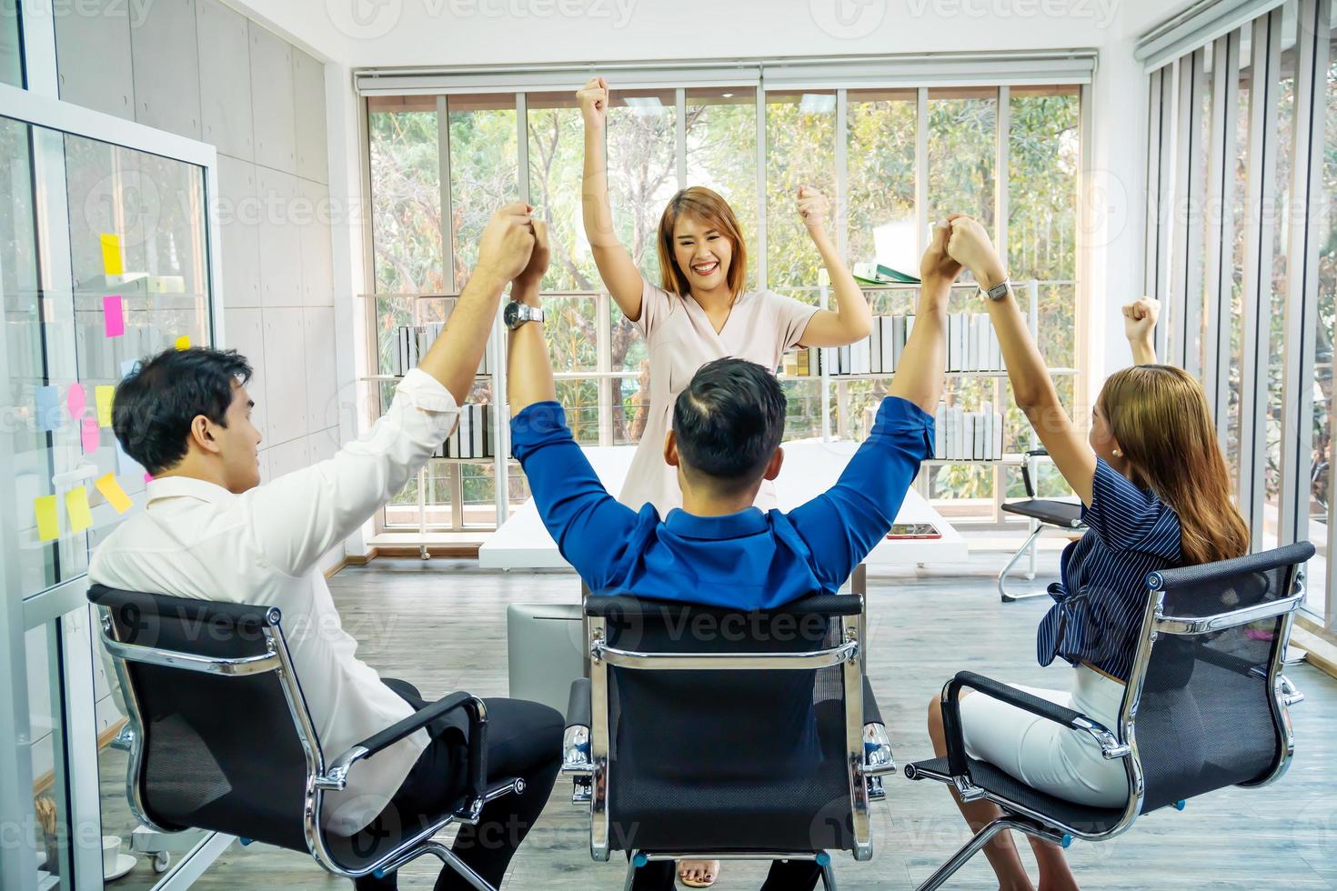 feliz grupo de negocios exitoso en la oficina, equipo de negocios celebrando un triunfo con los brazos arriba, logro trabajando en el concepto de oficina foto