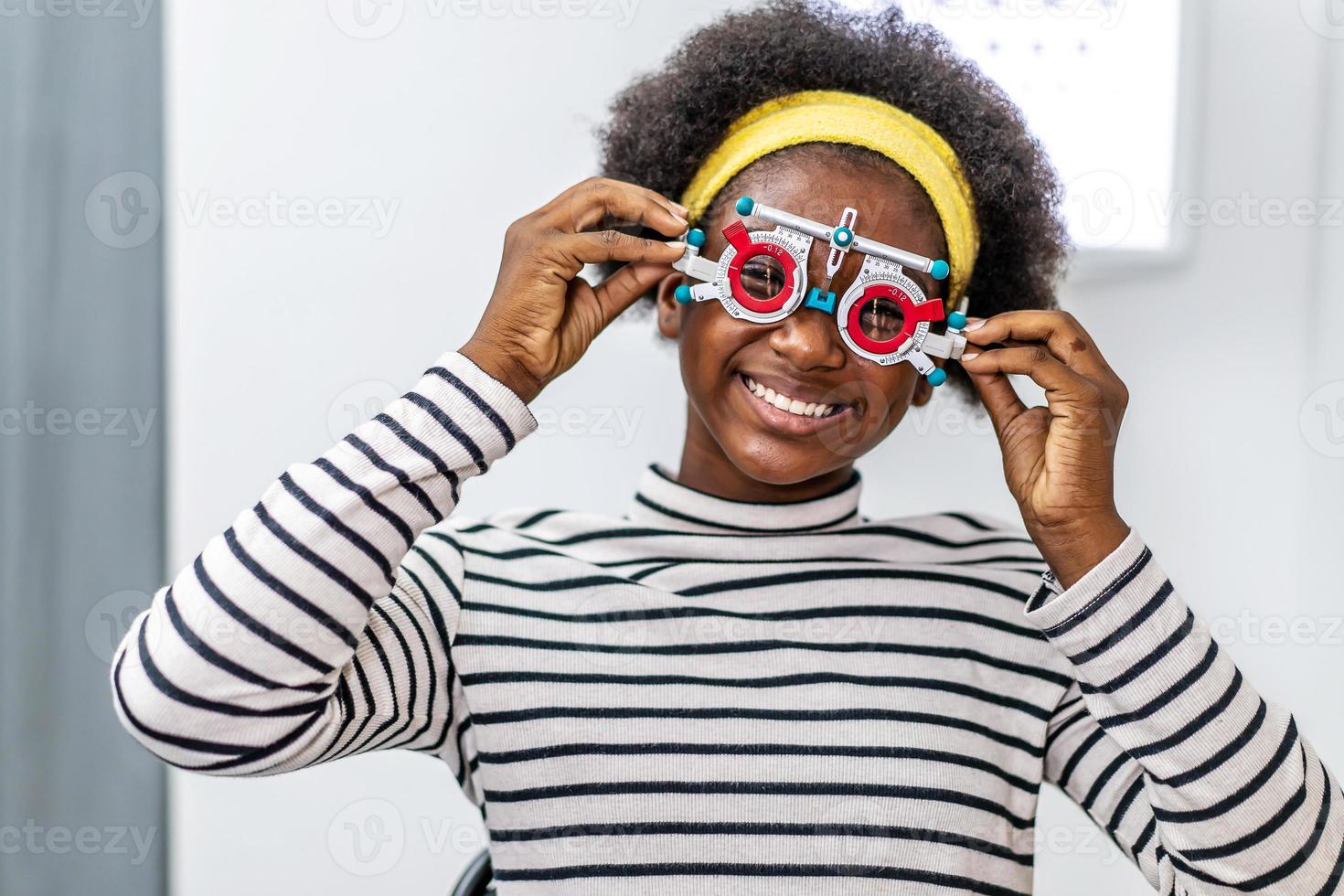 Smiling young woman african american checking vision with eye test glasses during a medical examination at the ophthalmological office, Checking eye vision by optician health examination concept photo