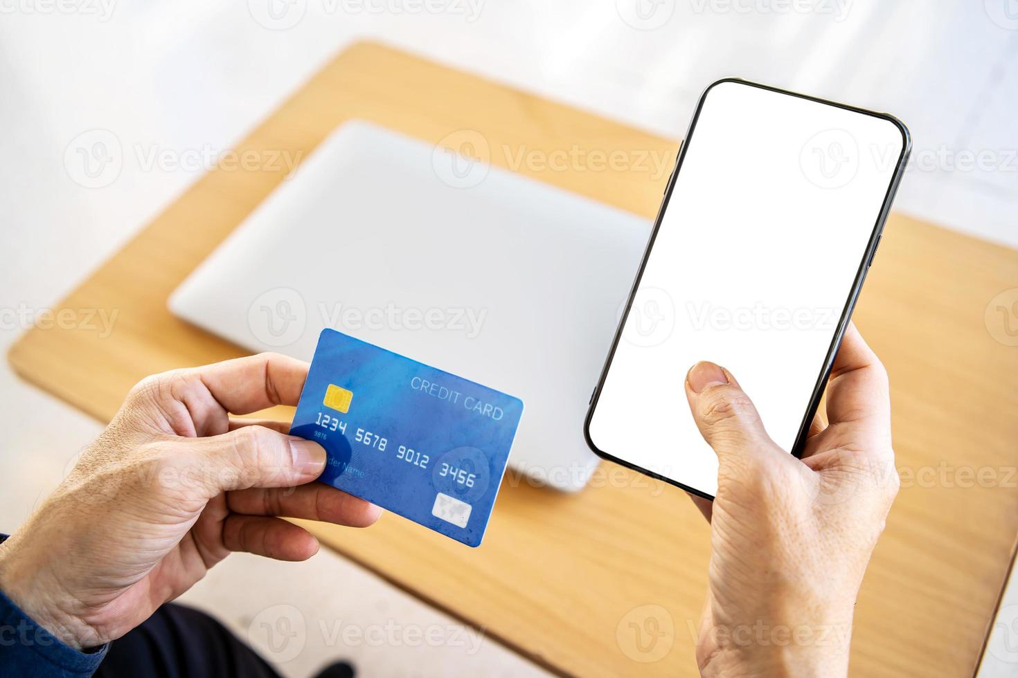 Online payment. Close Up man hands holding smartphone with blank screen and credit card, making financial transaction, smart phone for online shopping or reporting lost card photo