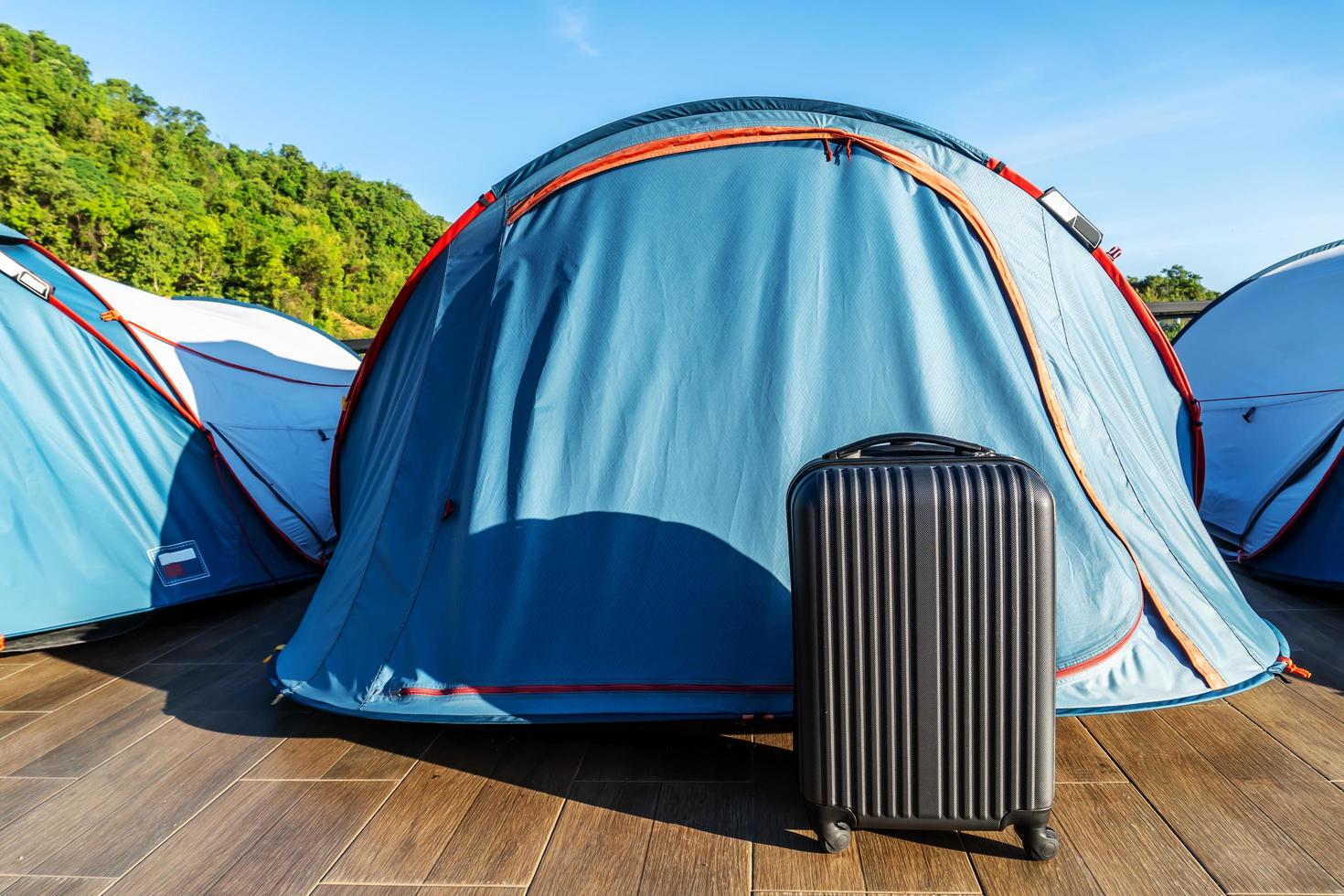 maletas de viaje en una tienda de campaña en el fondo del paisaje rural - vacaciones de verano alternativas en el parque nacional - viaje por carretera y concepto de libertad foto