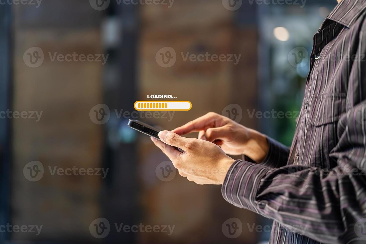 Hand man using mobile smartphone for download application and waiting to loading. Loading icon on screen. businessman downloading digital business data form website and cloud to smartphone photo