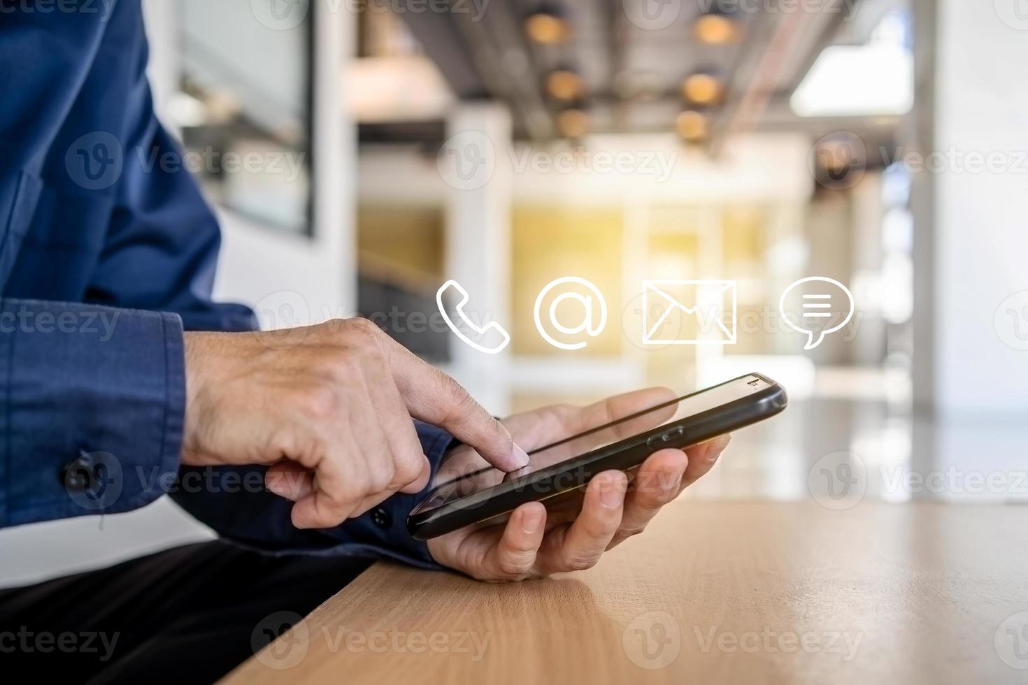Hotline service, Customer support hotline Contact us people connection. Businessman using Smart Phone with the email, call phone, address, Chat message icons photo