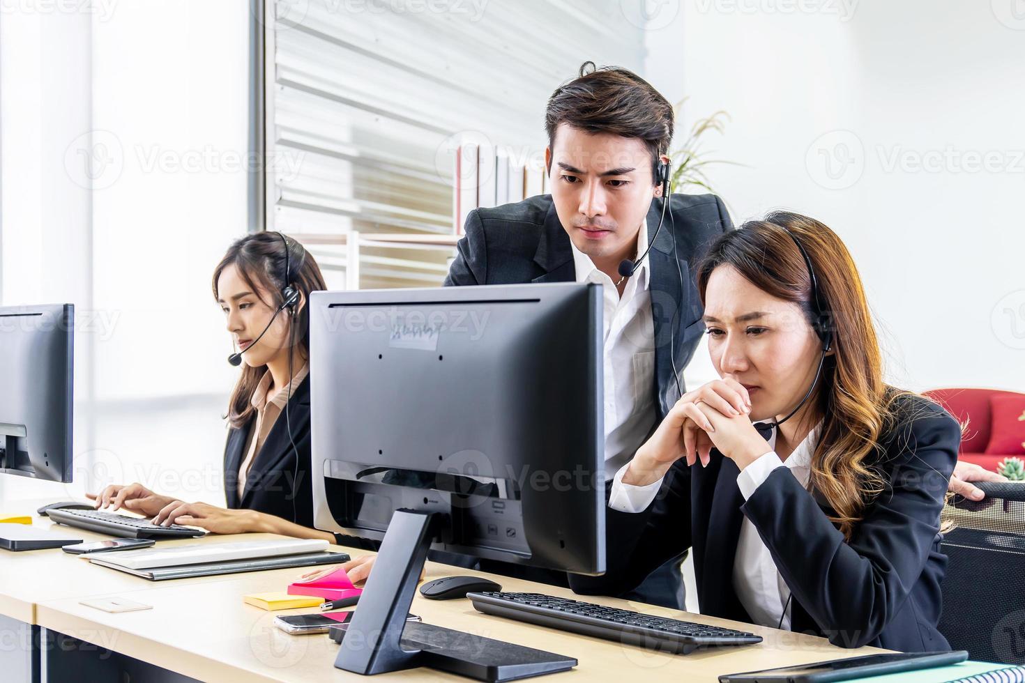 Group of young people with desktop computer in row and headset training with teacher instructor in customer service call support helpline business center photo