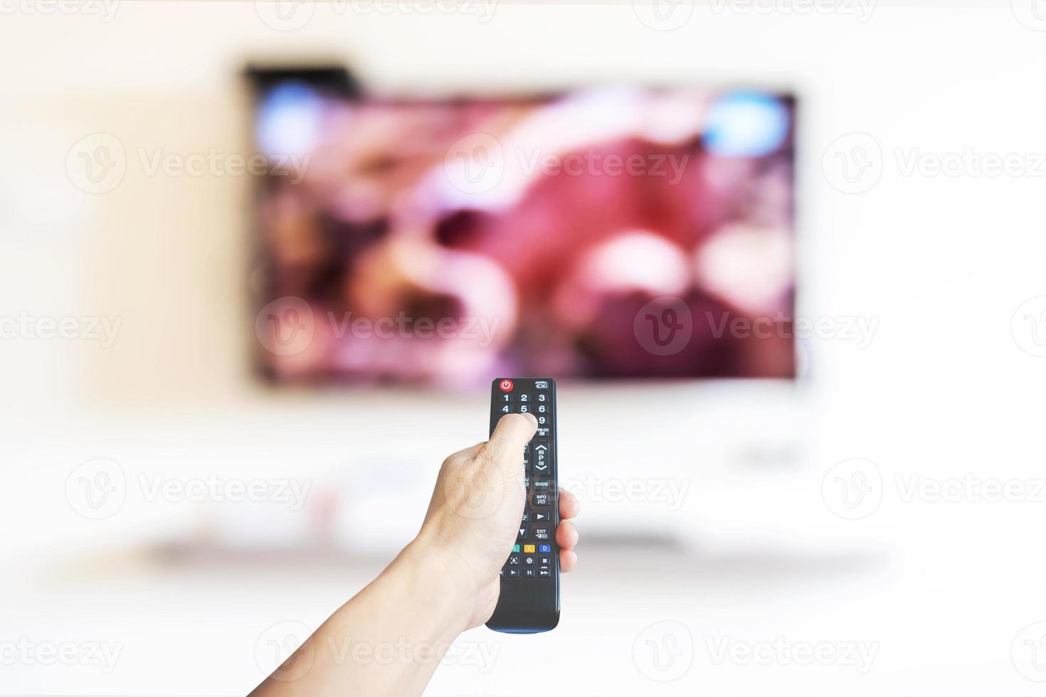 Hand holding television and audio multimedia remote control for watching tv photo