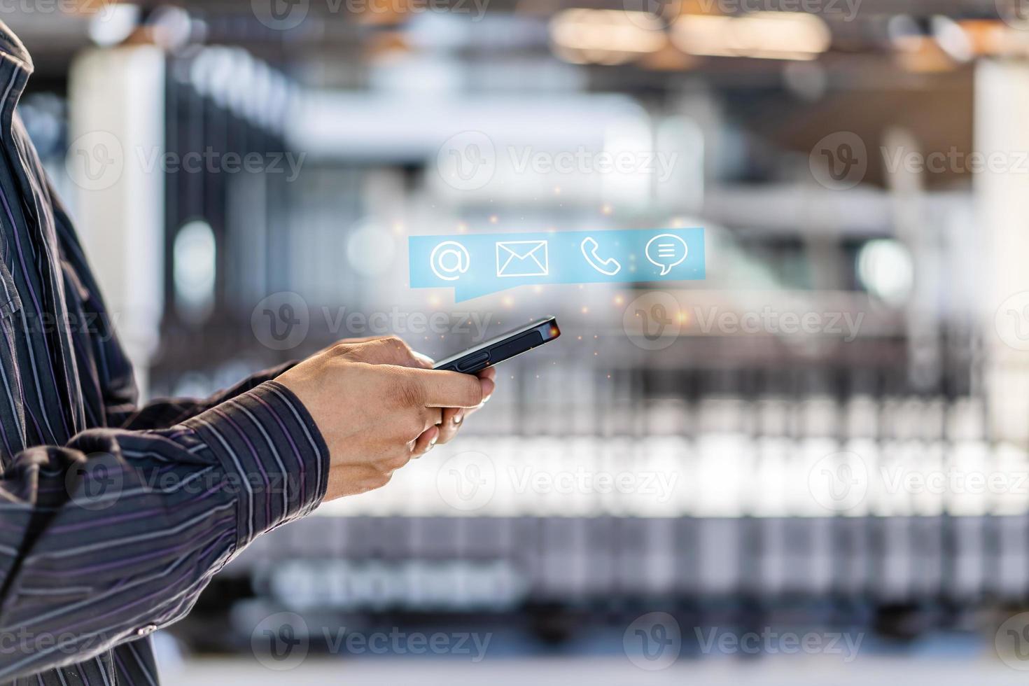 Hotline service, Customer support hotline Contact us people connection. Businessman using Smart Phone with the email, call phone, address, Chat message icons photo