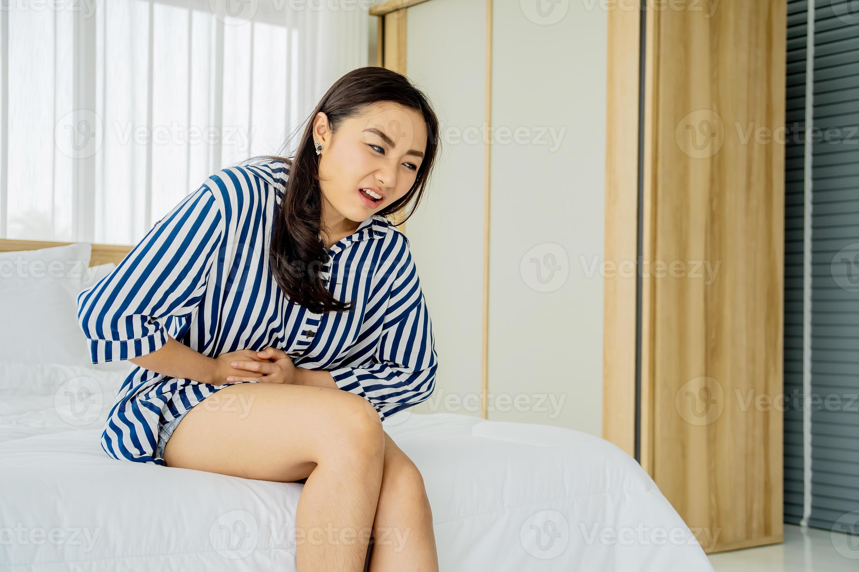 Asian Women Lag Pain On Bed In Bed Room In The Morning Stock Photo